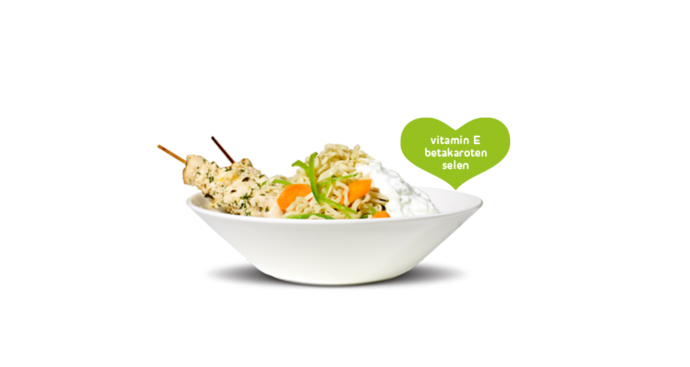 En skål med nudlar, grönsaker och köttspett med en hjärtformad etikett som lyfter fram vitamin E.