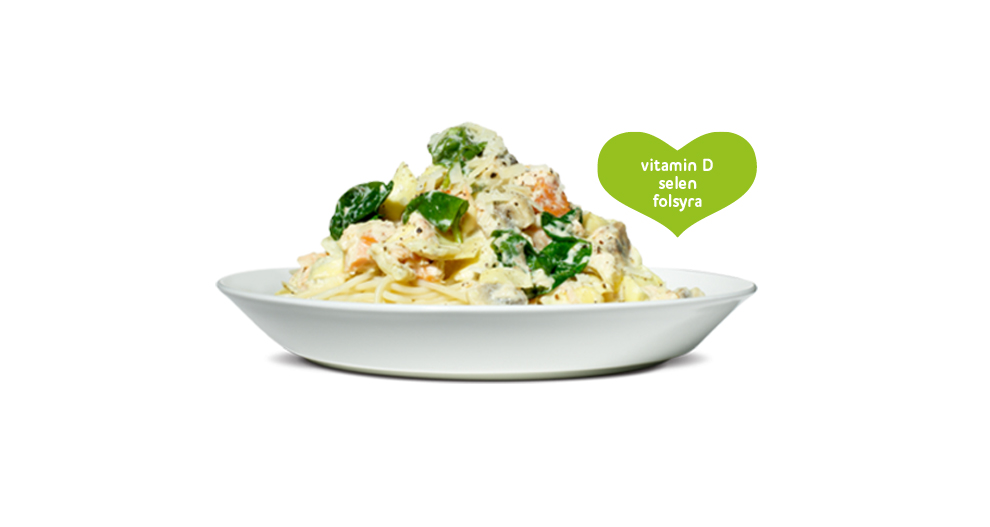 En skål med krämig pasta med grönsaker och en hjärtformad etikett som lyfter fram D-vitamin, selen och folat.