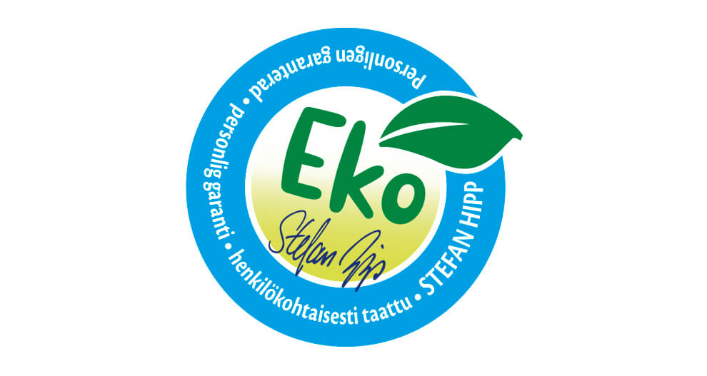 En cirkelformad logotyp med ordet "Eko" i mitten, omgivet av text på ett främmande språk och ett grönt blad uppe till höger.